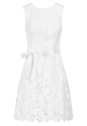 White lace dress with a sleeveless design, floral patterns, and a satin belt at the waist; scalloped hem detail.