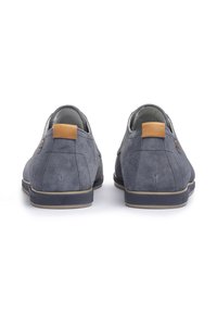 Scarpe slip-on in suede grigio con profilo basso, decorate con un accentuazione in pelle marrone sul tallone e suola in gomma texturizzata per una migliore aderenza.