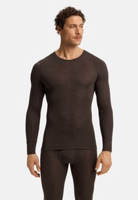 Camisa térmica de manga larga marrón hecha de tejido suave, con cuello redondo y un diseño ajustado que se adapta al cuerpo.