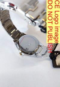 Armbandsur i rostfritt stål med silverfärgad länkarmband och en rund, genomskinlig baksida som avslöjar ett texturerat mönster. Guldaccent på kronan.