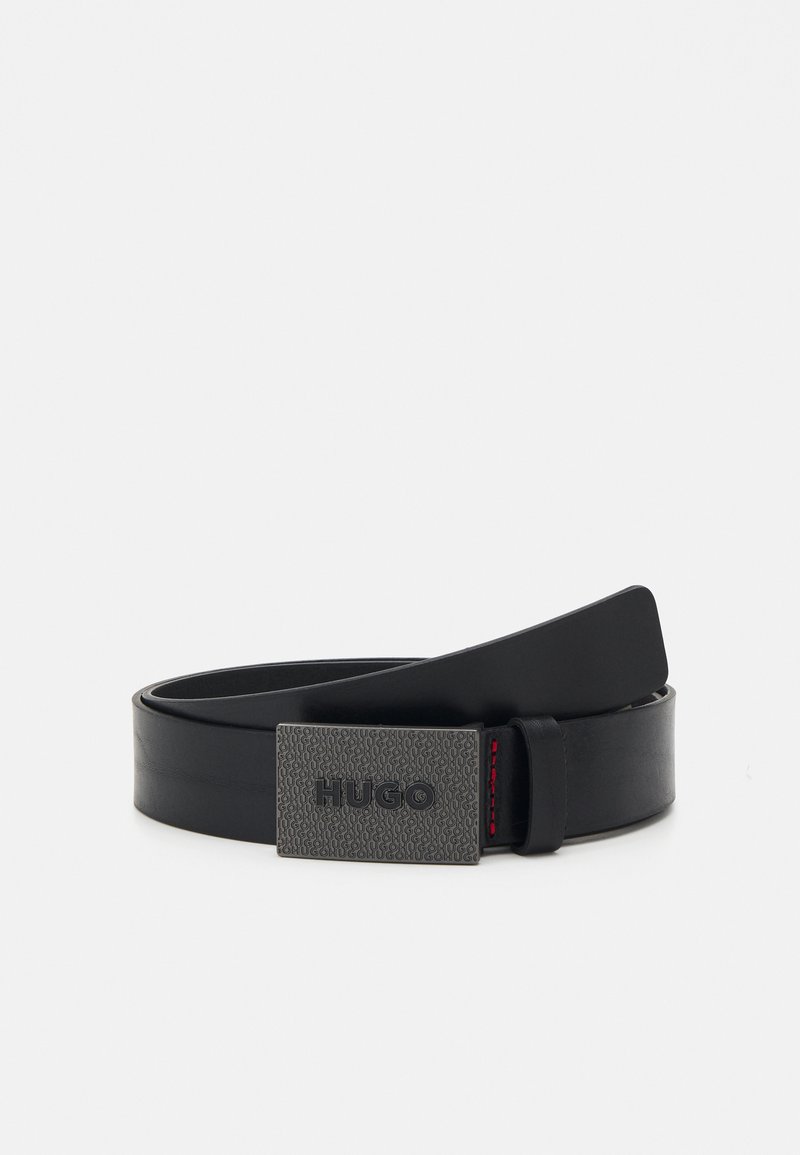 Must mustriba mustaja muste ises sades logoga "HUGO." Sisu sisaldab peent punast tikandit detaili klambris.