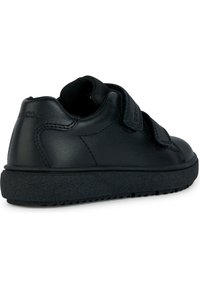 Sneaker in pelle nera con cinturini in velcro, punta arrotondata e suola in gomma testurizzata. Presenta un colletto imbottito e un dettaglio con logo sul tallone.