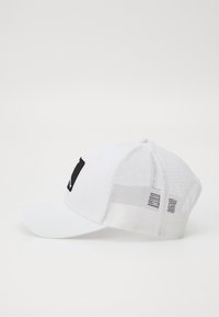 Hvit caps med buet skjerm, med en svart lapp foran og nettingpaneler bak for god ventilasjon.