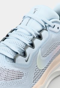 Šviesiai mėlynas bėgimo batelis su tinkline viršutine dalimi, tekstūruotomis raištelėmis, pilkais akcentais ir paminkštintu padu. Ant jo yra atspindinti Swoosh logotipas.