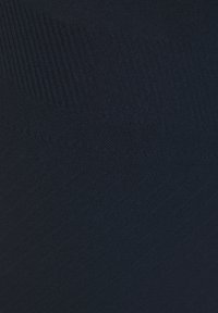 Genähtes navyfarbiges Gewebe mit glatter Textur, das dezente Rippungen und ein geometrisches Muster aufweist und unterschiedliche Dicken und Tiefen zeigt.
