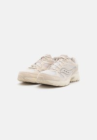 Helle beige Sportschuhe mit Netzeinsätzen, runder Zehenform und strukturierten Gummisohlen. Verfügt über ein Schnürdesign und reflektierende Akzente.