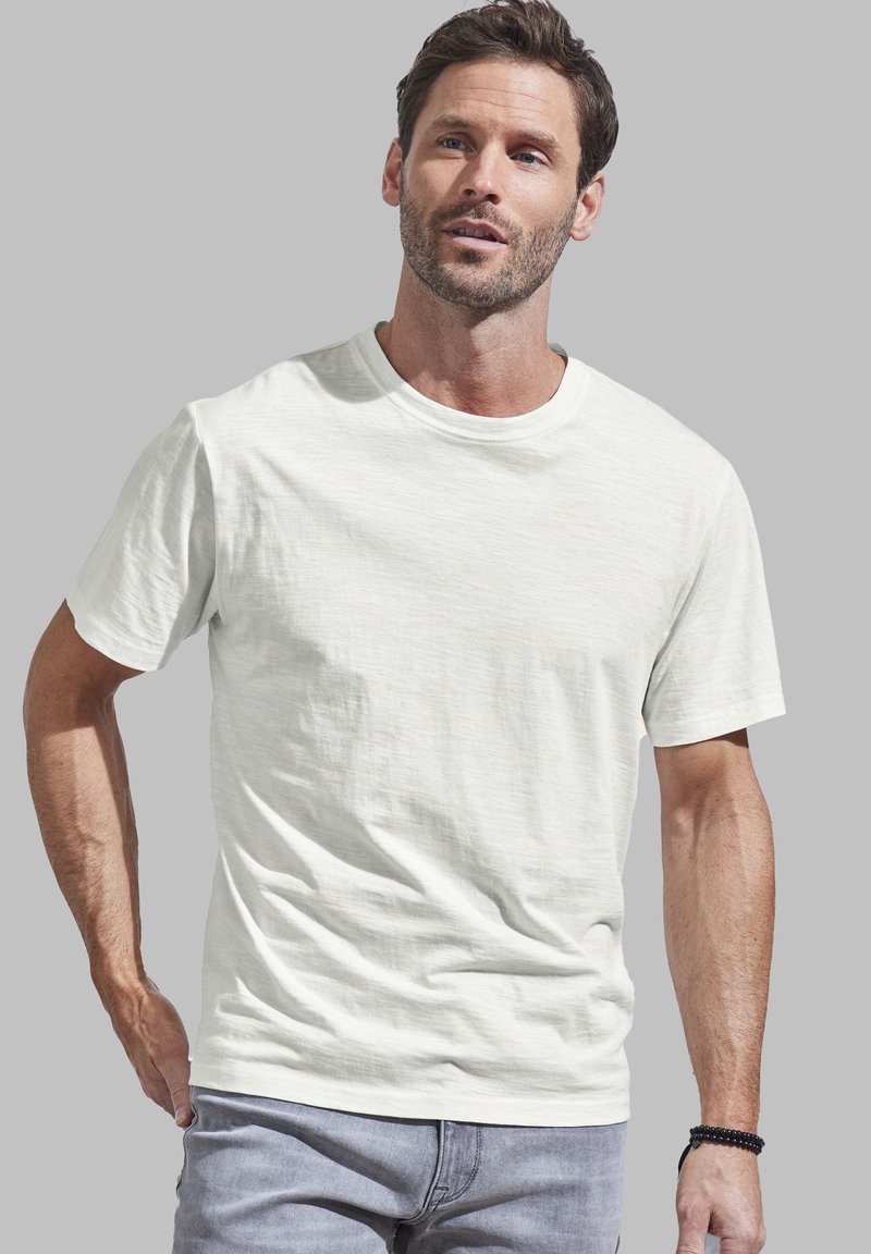 T-shirt a maniche corte con scollo rotondo in grigio chiaro, realizzato in tessuto morbido con una leggera texture e vestibilità comoda, abbinato a jeans grigi casual.