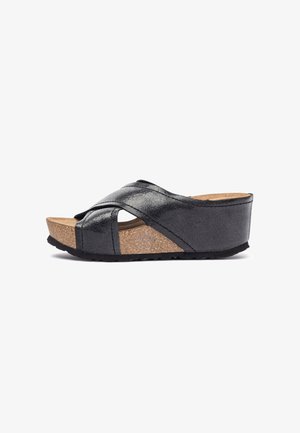 Sandalias de cuña con tiras cruzadas negras, con una plantilla de corcho y un acabado texturizado, que cuentan con una suela de goma para mayor agarre y comodidad.