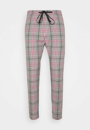 Grå og lyserøde ternede bukser med konisk pasform og sort snøre i taljebåndet, vist fladt mod hvid baggrund.