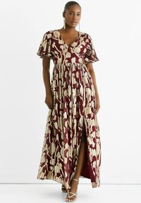 Maxi dress in burgundy with gold floral pattern, featuring a deep V-neck, short flutter sleeves, and a side slit, made from lightweight fabric.