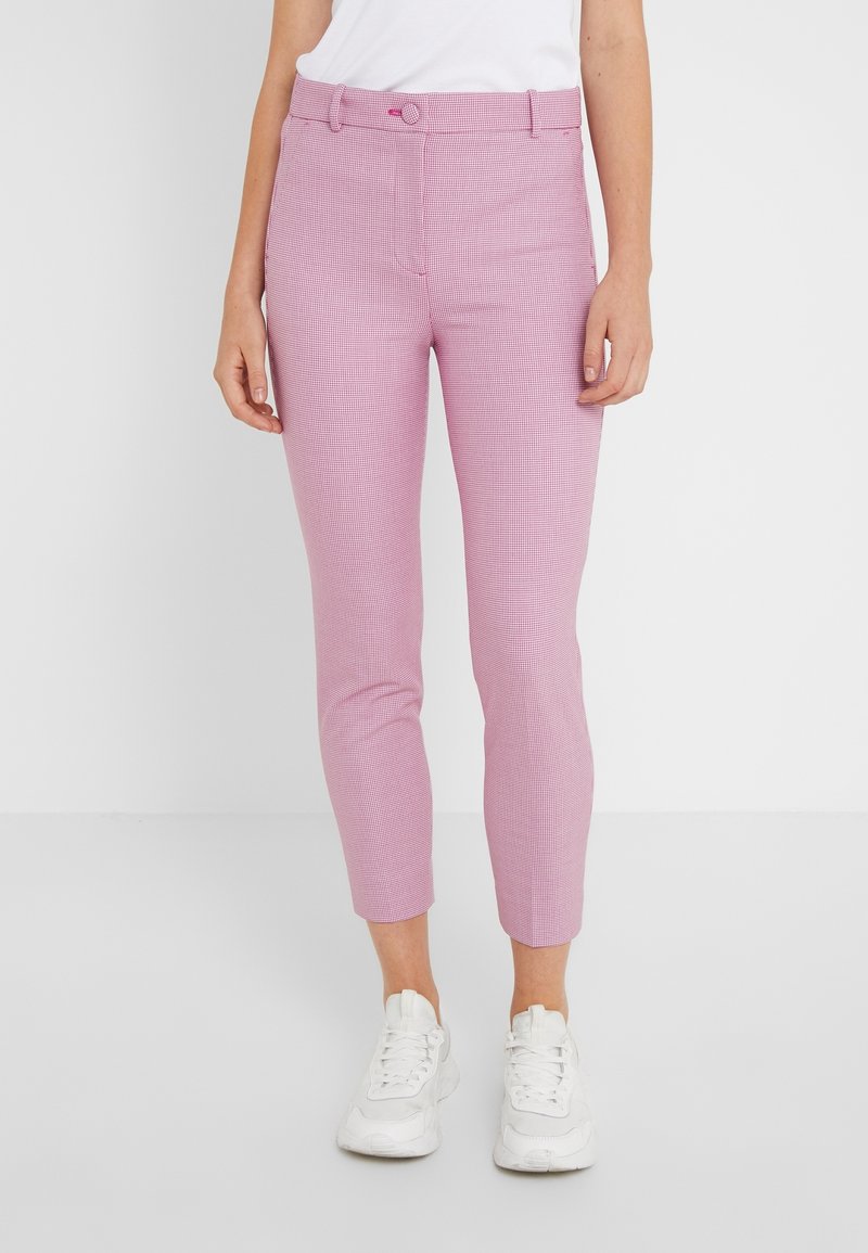 Roze gestipte broeken met een slim fit, voorzien van een middelhoge tailleband en een knoopsluiting, gecombineerd met witte sneakers.