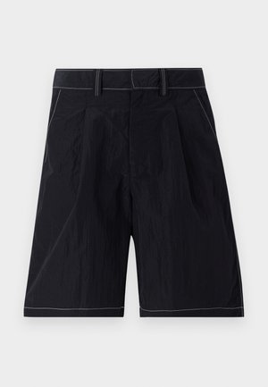 Calções pretos feitos de um tecido leve com um acabamento texturizado. Apresentam um frente lisa, bolsos laterais e costuras brancas contrastantes.