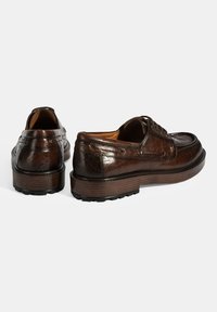 Braune Lederschuhe mit strukturierter Oberfläche, runder Spitze und Schnürsenkeln. Die Sohle ist braun mit einer holzähnlichen Optik und einem schwarzen Gummiboden.