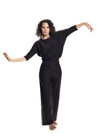 Black loose-fitting top with three-quarter sleeves and high-waisted black trousers featuring side pockets. Smooth texture, minimalist design.