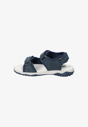 Granatowy sandał z odkrytymi palcami, regulowanymi paskami, białą wyściełaną podeszwą i teksturowaną czarną podeszwą zewnętrzną do użytku na zewnątrz.