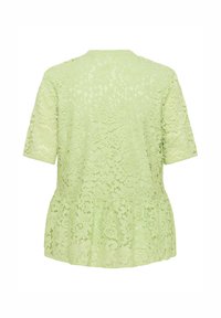 Világoszöld csipke felsőrész rövid ujjakkal és peplum aljjal. Virágmintás és texturált felülettel rendelkezik.