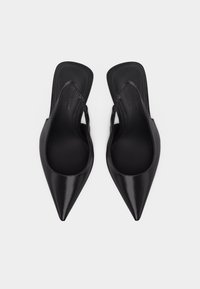 Paire de ballerines slingback en cuir verni noir avec bout pointu, bout carré et talon bas, vue de dessus sur fond blanc.