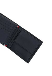 Portefeuille en cuir noir avec plusieurs emplacements pour cartes, un design plié et une texture lisse avec des accents rouges et blancs.