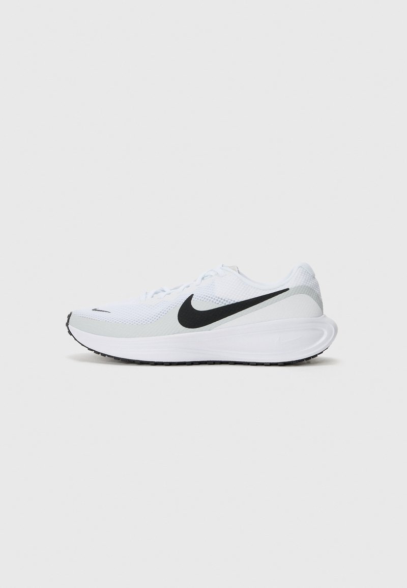 Baskets de sport blanches avec logo Nike swoosh noir, empeigne en mesh et semelle blanche épaisse sur fond gris clair uni.