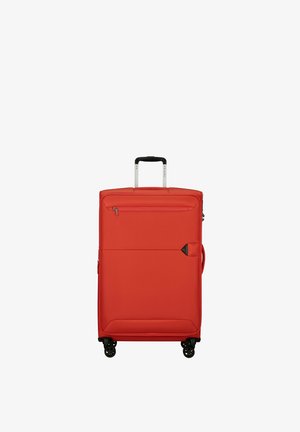 Red soft-shell suitcase with four black spinner wheels, a front zipper pocket, and an extended black handle.