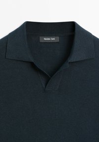 Polo in maglia blu scuro navy con collo a coste e una piccola etichetta brandizzata all'interno dello scollo con la scritta "Massimo Dutti."