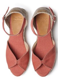 Espadrillas in tela rossa con design incrociato, dettagli in juta testurizzata, cinturino alla caviglia e fodera interna liscia. Presentano un marchio impresso.