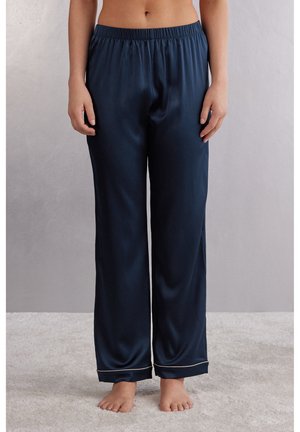 Navy satin pyjamasbyxor med elastisk midja, rak bendesign och ljusfärgad pipning vid fållarna. Mjuk textur och slät finish.