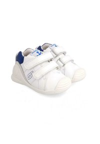 Zapatillas blancas con acentos azules, que presentan una puntera redondeada, correas de gancho y bucle, y una suela de goma texturizada. Número '6' en el lateral.