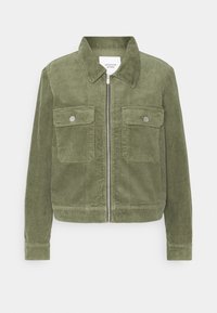 Giacca di velluto a coste verde oliva con zip frontale, due tasche sul petto con patte a bottone e colletto. Tessuto a coste e polsini aderenti.