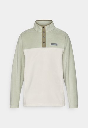 Columbia pulover s dizajnom u svijetlozelenoj i krem boji, od flisa, polu ovratnikom, s četiri crna gumba za zatvaranje i oznakom logotipa.