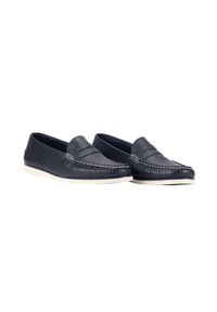Mocasines de piel azul marino con costuras blancas y suela de un crema claro, con una textura suave y un diseño clásico de tipo slip-on.