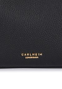 Crni kožni novčanik s teksturiranim završetkom. Zlatni folijski logotip "CARLHEIM COPENHAGEN" utisnut na prednjoj strani.