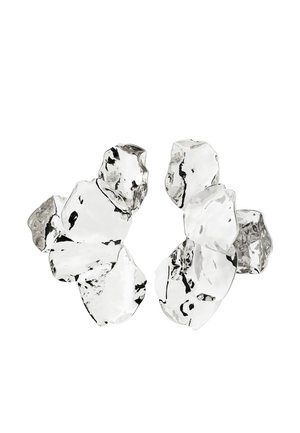 Cluster van zes onregelmatig gevormde, doorschijnende en reflecterende glasachtige stukken die zijn gerangschikt op een witte achtergrond.