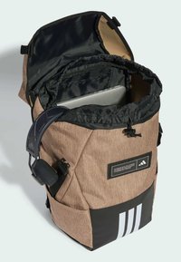 Brauner und schwarzer Rucksack mit verstellbarem Tragegurt, umklappbarem Deckel, Nylon-Oberfläche, Innenfach und drei weißen Streifen auf der Vorderseite.