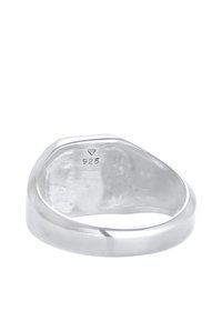 Sterling silver ring with a smooth, polished surface. Inside marked “925,” indicating quality standard. Flat band design.