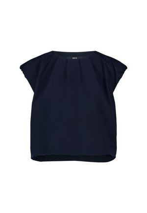 Blouse bleu marine à manches courtes avec encolure froncée et coupe ample, étiquette "zero" visible au niveau du col.