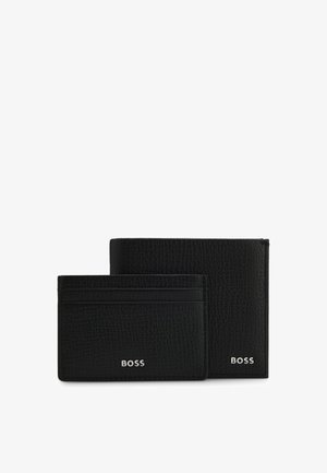 Ensemble de portefeuille en cuir noir comprenant un porte-cartes et un portefeuille. Fini texturé avec le logo "BOSS" en relief argenté sur les deux pièces.