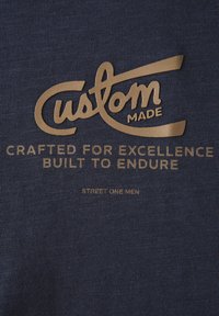 Námořnická tkanina se zlatým textem "Vyrobeno na míru," "Zpracováno pro dokonalost, vyrobeno, aby vydrželo," a "Street One Men."