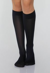 Černé ponožky do půli lýtek vyrobené z jemného, průsvitného materiálu s hladkým povrchem a elastickým páskem nahoře, s otevřenou špičkou.