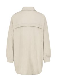 Beige textured shirt with a relaxed fit, featuring a back yoke and long sleeves with elastic cuffs. Woven fabric has a crinkled finish.