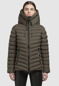 Olīvzaļa pūkainā jakā ir augsta apkakle, ar rāvējslēdzējs, un horizontālas šuves. Tā ir aprīkota ar rāvējslēdzēja kabatām un kapuci ar auklu.