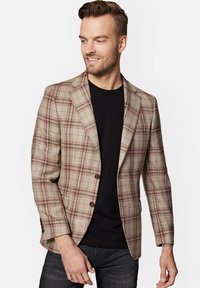 Beżowa marynarka w kratkę w kolorze brązowym i rdzawym, z klapami z wycięciem i dwoma przednimi guzikami, stylizowana na czarnej koszuli.