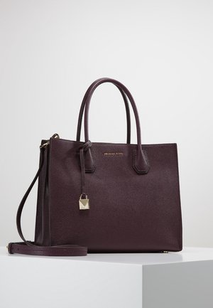 Lilla lædertaske med to øverste håndtag, en aftagelig skulderrem og en gylden låse-detalje. Tekstureret yderside og minimalistisk design.