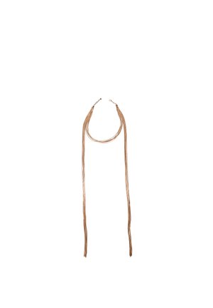 Dolga večnitenka zlata verižica z zaponko, niti visi navzdol in so na vrhu rahlo zavite v zanko.
