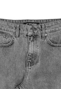 Jeans in denim grigio con vita alta, chiusura con bottone metallico, tasca frontale discreta e caratteristica texture slavata su tutta la superficie.