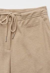 Pantaloni beige con tessuto testurizzato, elastico in vita, coulisse annodata davanti e una tasca posteriore; tessuto liscio con motivo sottile.