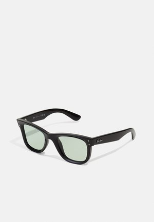 Black plastic sunglasses with green lenses. Square frame design featuring silver accents at the hinges. Textured temple arms.