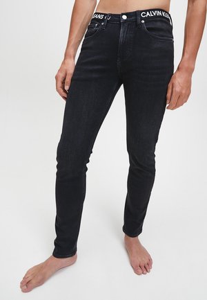 Zwarte denimjeans met een slim fit, met een merkemblem op de tailleband en voorzakken, ontworpen in een klassieke vijf-zakkenstijl.