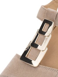 Beige suède schoenband met drie verbonden glanzende gouden rechthoekige gespen op een tankleurige binnenzool.