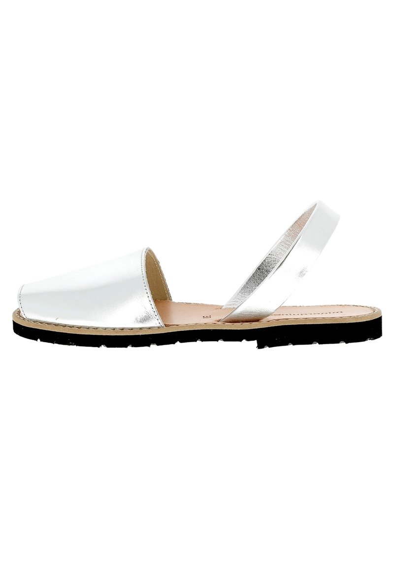 Sandales en cuir métallisé blanc avec un large devant, bride de cheville ajustable et semelle en caoutchouc noir. Texture lisse avec un design minimal.